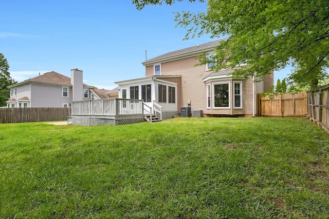 rear view of house with a lawn, central AC unit, and a deck