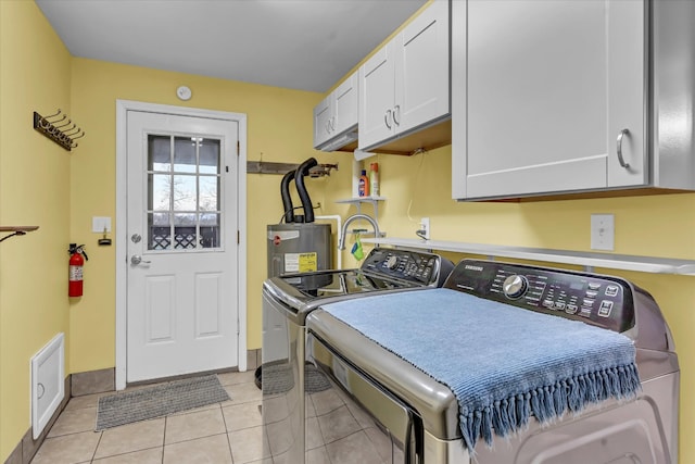 laundry area featuring light tile patterned flooring, cabinets, electric water heater, and washing machine and clothes dryer