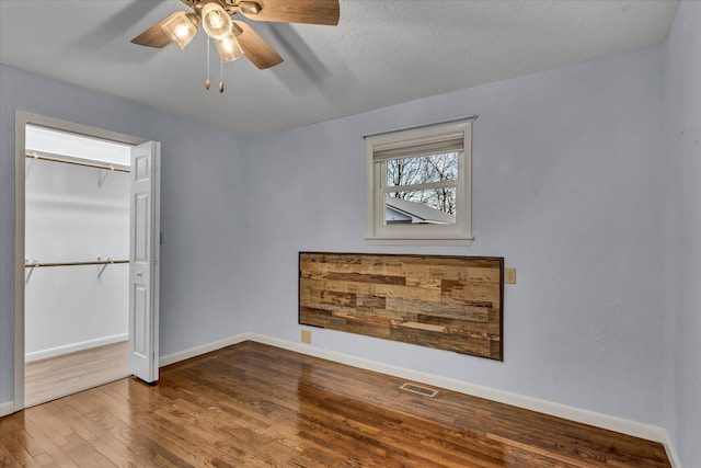 spare room with hardwood / wood-style floors, ceiling fan, and a textured ceiling