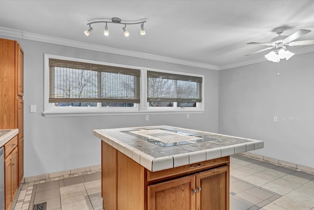 kitchen with tile countertops, a center island, a healthy amount of sunlight, and ornamental molding