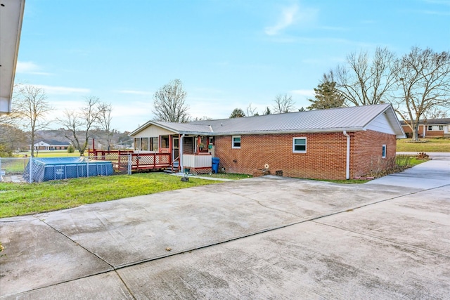 back of house with a yard and a pool side deck