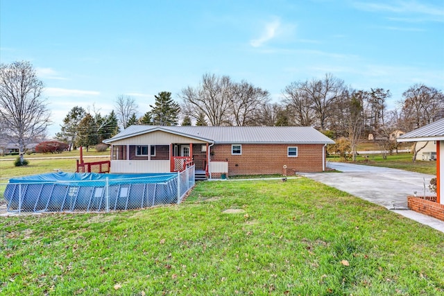 back of house with a swimming pool side deck and a yard