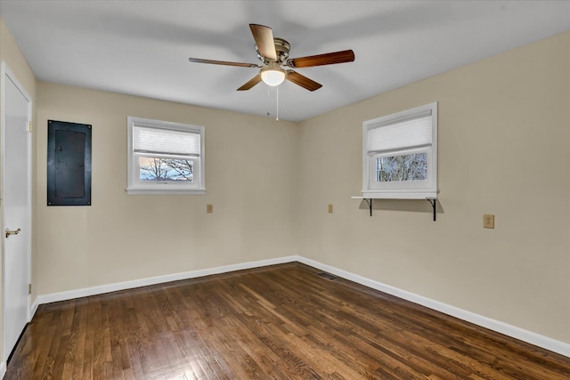 spare room with dark hardwood / wood-style floors, ceiling fan, and electric panel