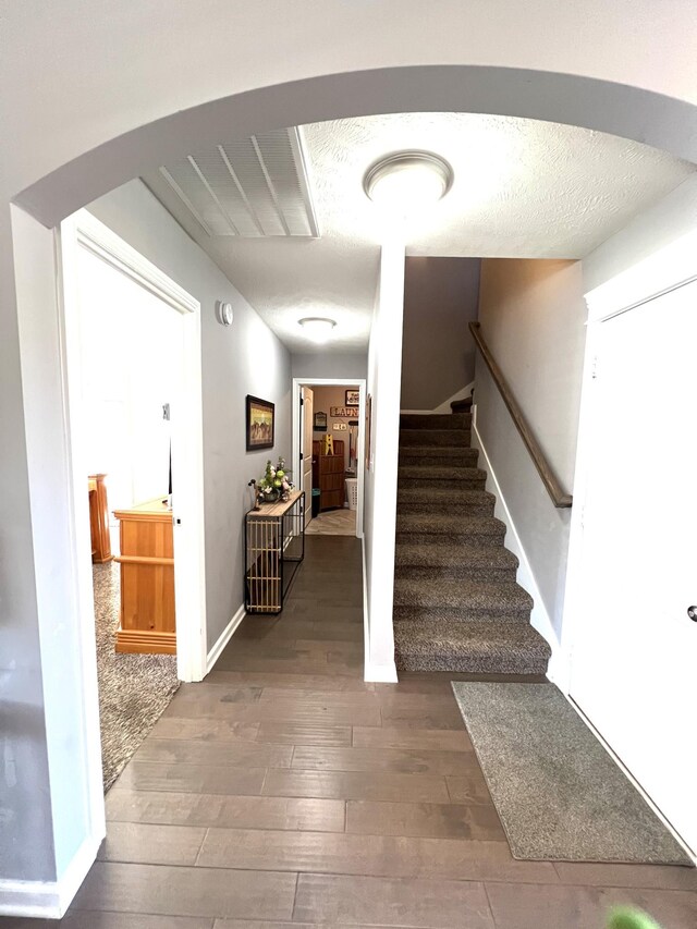 entrance foyer featuring a textured ceiling and dark wood-type flooring