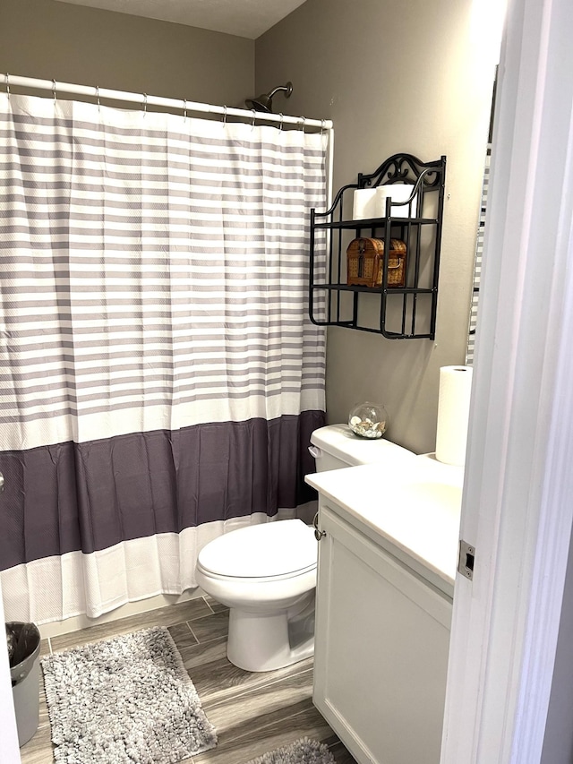 bathroom with hardwood / wood-style flooring, vanity, and toilet