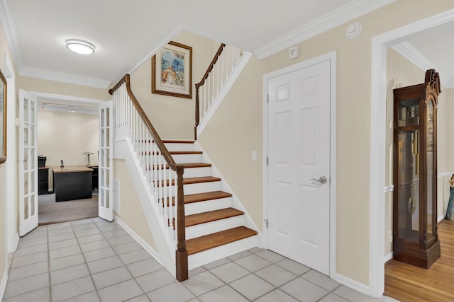 stairway with tile patterned floors and crown molding