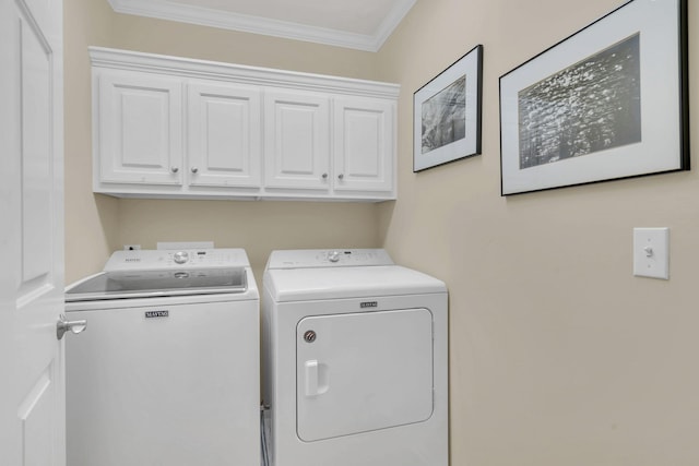 washroom with cabinets, washer and clothes dryer, and crown molding