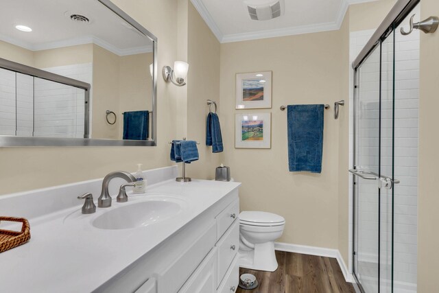 bathroom featuring hardwood / wood-style floors, vanity, toilet, ornamental molding, and walk in shower