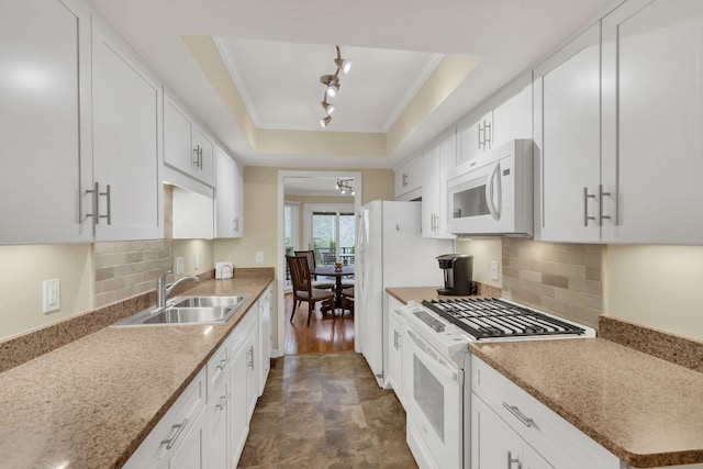 kitchen featuring white cabinets, white appliances, a raised ceiling, and backsplash