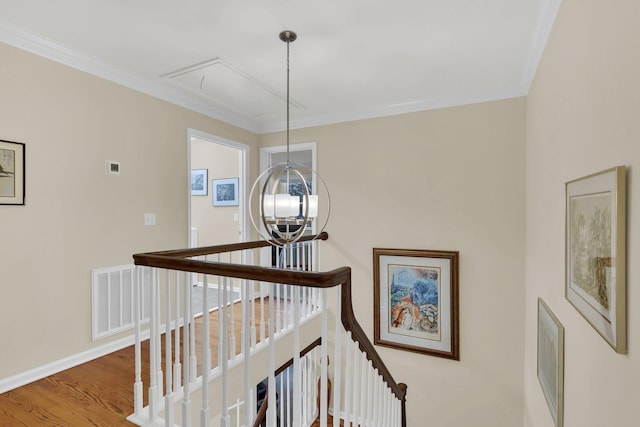 stairs with a chandelier, hardwood / wood-style floors, and ornamental molding