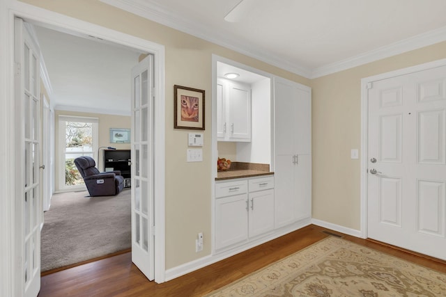 interior space featuring french doors, light hardwood / wood-style floors, and ornamental molding