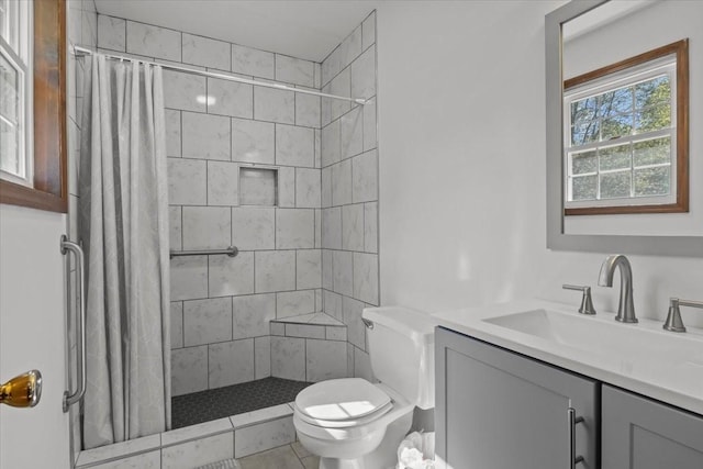 bathroom featuring tile patterned floors, vanity, toilet, and walk in shower