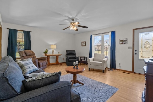 living room with light hardwood / wood-style floors and ceiling fan