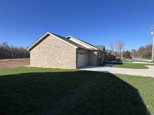 view of side of home with a yard and a garage