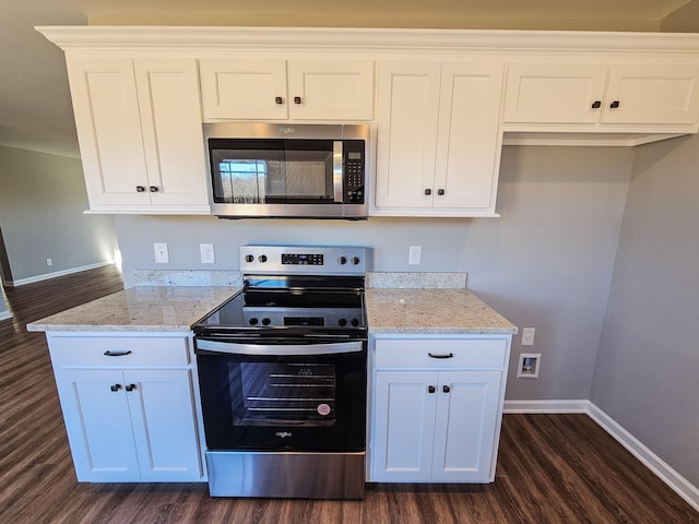 kitchen featuring white cabinets, dark hardwood / wood-style flooring, light stone countertops, and stainless steel appliances