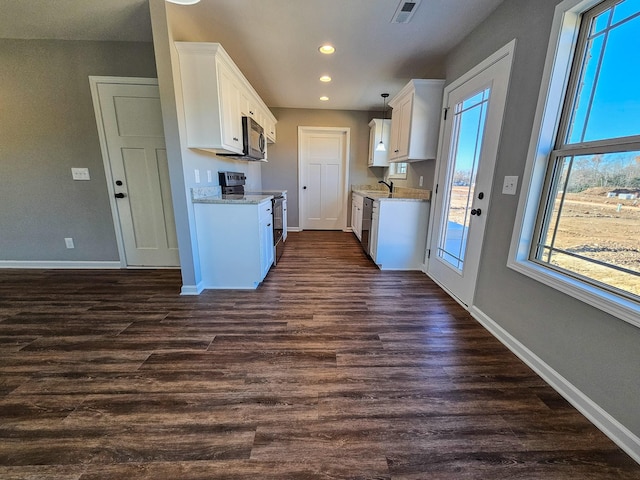 kitchen with a wealth of natural light, dark hardwood / wood-style flooring, white cabinets, and electric range oven