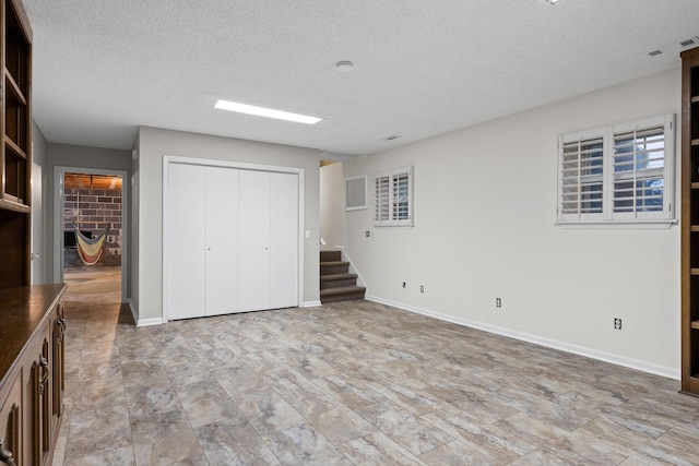 unfurnished bedroom with a fireplace, a textured ceiling, and a closet