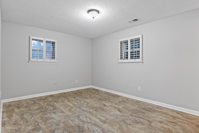 spare room with a textured ceiling