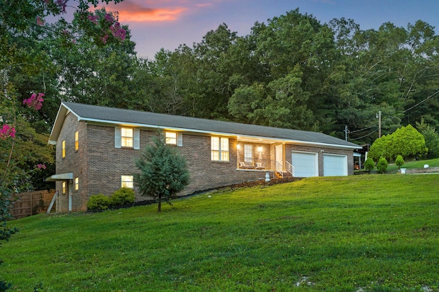 view of front of home with a yard and a garage