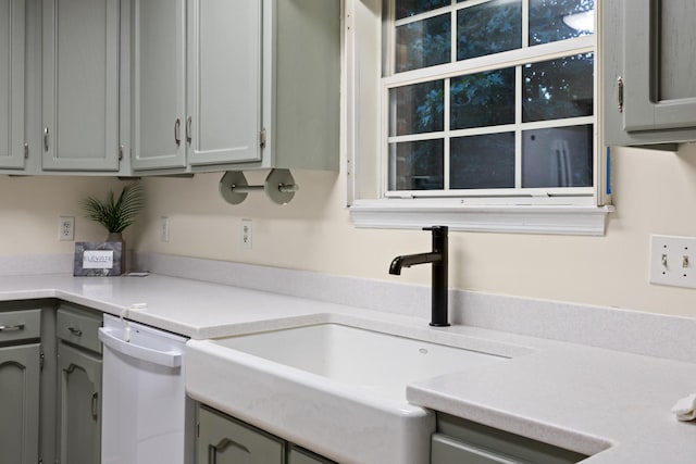 kitchen featuring dishwasher, gray cabinets, and sink