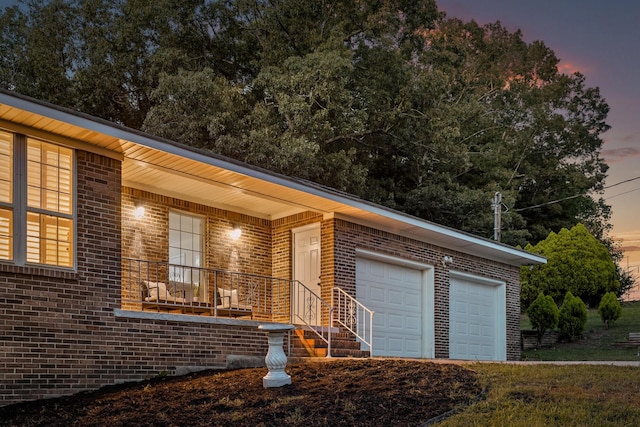 ranch-style home with a porch and a garage