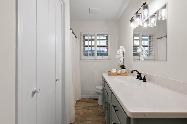 bathroom with a wealth of natural light, vanity, and toilet