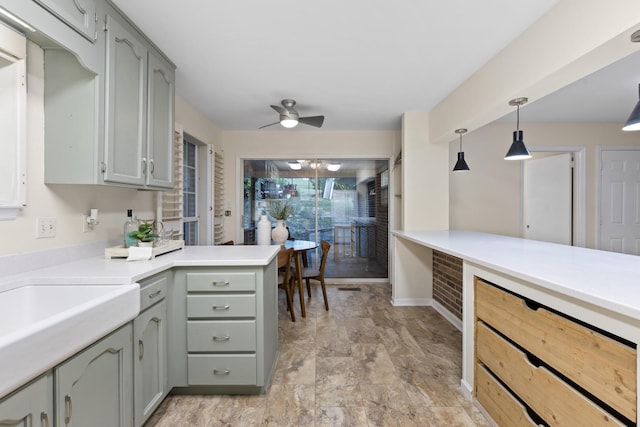 kitchen featuring kitchen peninsula, pendant lighting, ceiling fan, and gray cabinetry