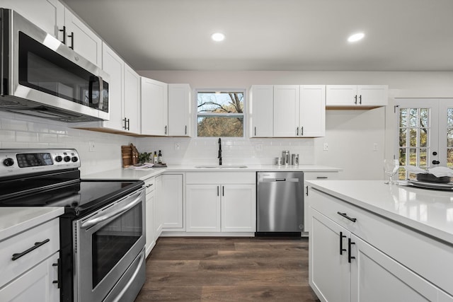 kitchen with dark hardwood / wood-style flooring, sink, white cabinets, and stainless steel appliances