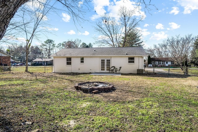 back of property featuring a yard, french doors, a fire pit, cooling unit, and a patio