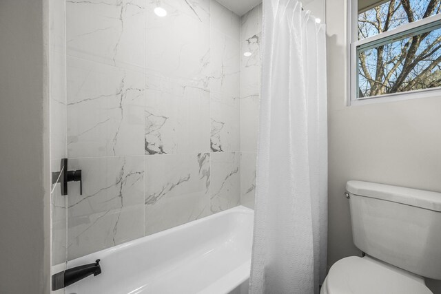 bathroom with shower / bath combination with curtain and toilet