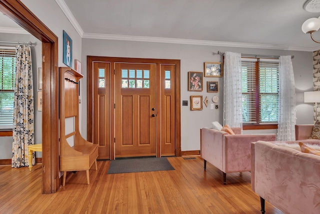 entrance foyer with light hardwood / wood-style flooring and crown molding