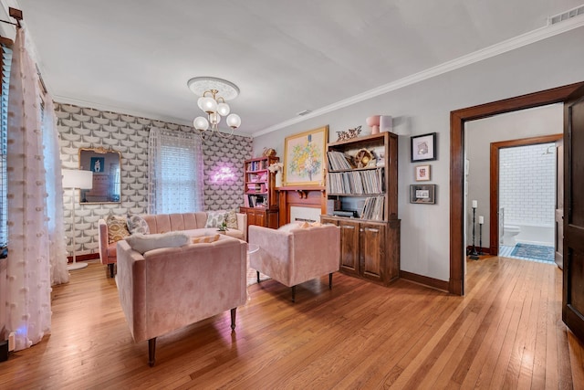 living room featuring crown molding, a notable chandelier, and light wood-type flooring