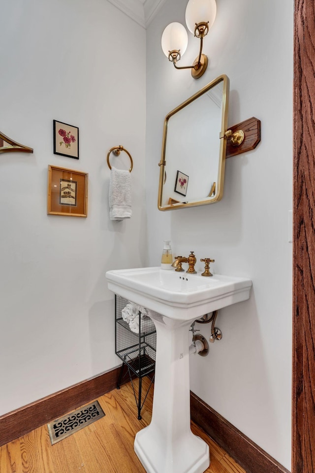 bathroom with crown molding and hardwood / wood-style floors