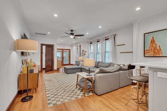 living room featuring crown molding, ceiling fan, and light wood-type flooring