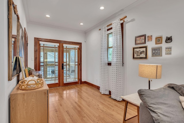 interior space featuring crown molding, french doors, and light wood-type flooring