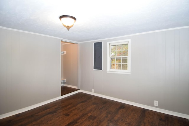 unfurnished room featuring electric panel, crown molding, and dark hardwood / wood-style flooring