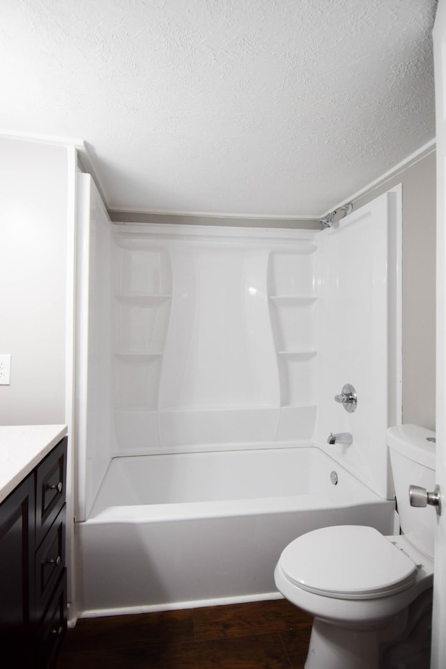 full bathroom featuring vanity, bathing tub / shower combination, toilet, a textured ceiling, and wood-type flooring