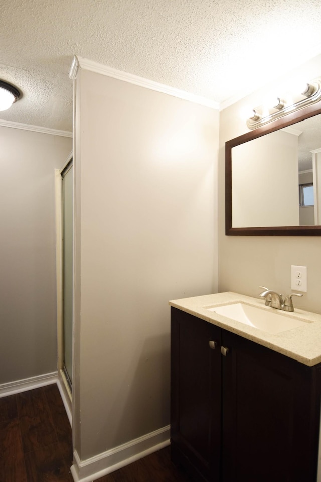 bathroom featuring a textured ceiling, vanity, hardwood / wood-style flooring, and crown molding