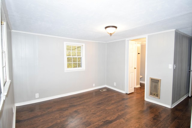 unfurnished room featuring crown molding, dark wood-type flooring, and heating unit