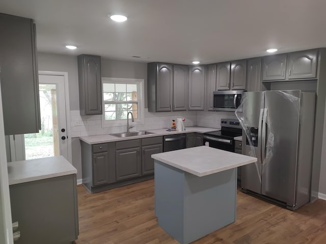 kitchen featuring a kitchen island, appliances with stainless steel finishes, sink, and dark wood-type flooring