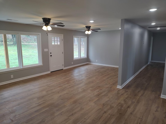 entrance foyer featuring ceiling fan, a wealth of natural light, and dark hardwood / wood-style flooring