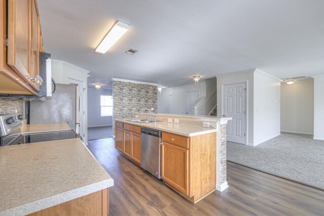 kitchen with dark hardwood / wood-style flooring, stainless steel appliances, crown molding, sink, and a center island with sink