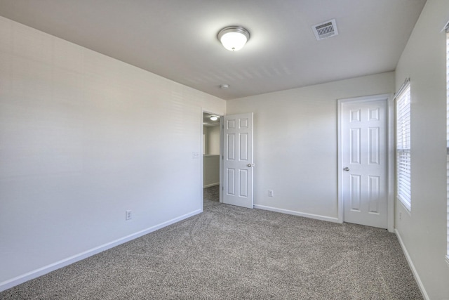 unfurnished bedroom featuring carpet flooring and multiple windows