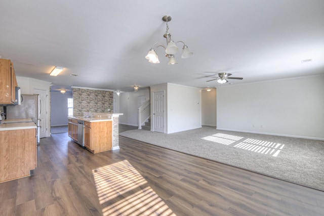 kitchen with appliances with stainless steel finishes, ceiling fan with notable chandelier, a center island, dark hardwood / wood-style floors, and hanging light fixtures