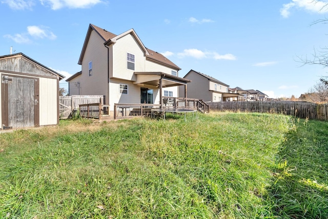 rear view of property with a shed and a wooden deck