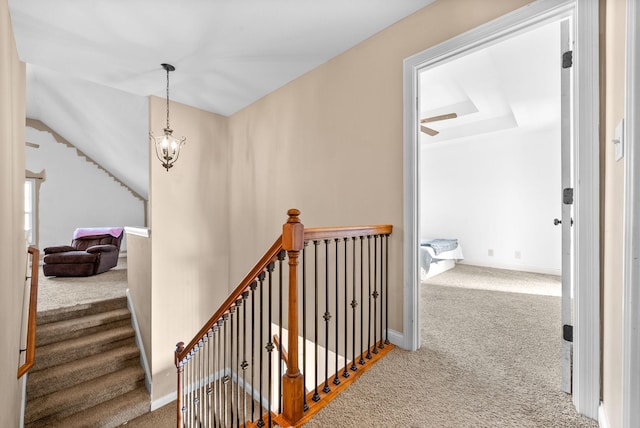 staircase with carpet flooring and a chandelier