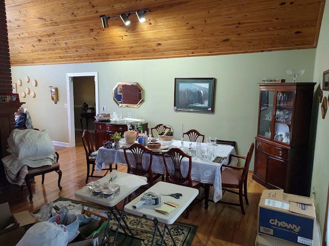 dining room with rail lighting, hardwood / wood-style flooring, vaulted ceiling, and wood ceiling