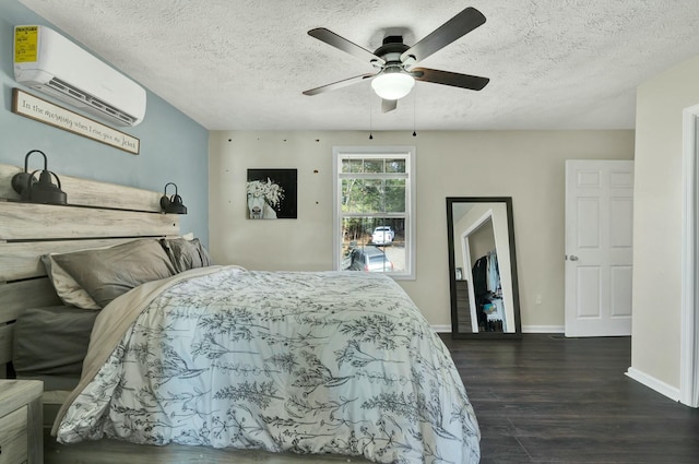 bedroom featuring a textured ceiling, dark hardwood / wood-style floors, a wall unit AC, and ceiling fan