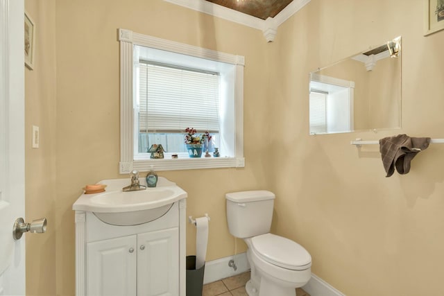 bathroom with tile patterned floors, crown molding, vanity, and toilet