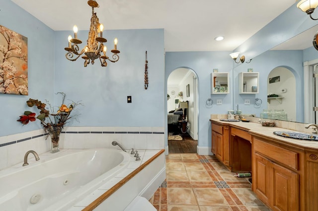 bathroom featuring tiled bath, tile patterned flooring, vanity, and a notable chandelier